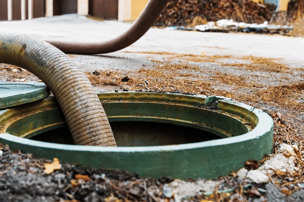 Septic tank riser and pump truck hose on a residential property in Auburn, AL