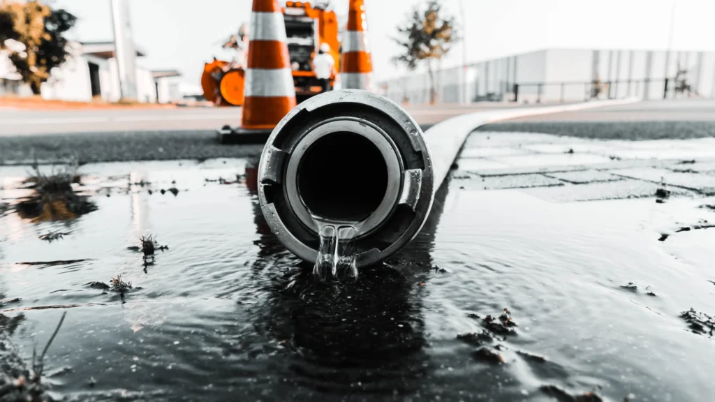 Septic hose fitting draining water on a job site in Auburn, AL